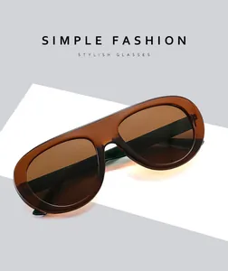 Detail of amber shield sunglasses on a white geometric stand with Simple Fashion text