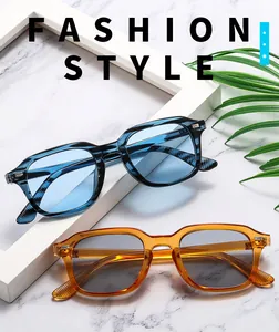 Detail of square sunglasses with silver metal rivets on transparent blue and amber frames