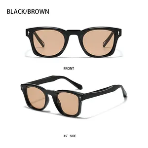 Close-up of square black sunglasses with brown lenses and silver arrow accents