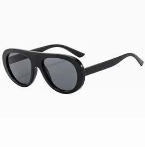 Detail view of glossy black retro aviator sunglasses with thick temples and gray lenses