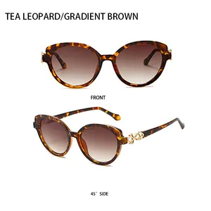 Detail of tortoise shell sunglasses with gradient brown lenses and gold metal hinges