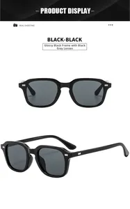 Detail of glossy black square sunglasses with silver rivets and dark grey lenses