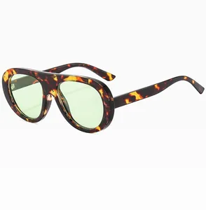 Detail of tortoiseshell frame sunglasses with light green lenses and a retro single-bridge design
