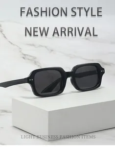 Detailed macro view of black rectangle sunglasses with silver rivets on marble background