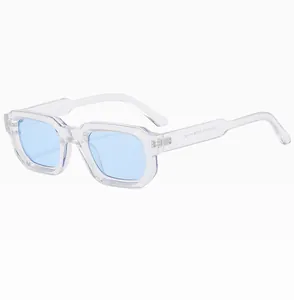 Dettaglio degli occhiali da sole rettangolari trasparenti con lenti blu e montatura