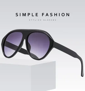 Detail of oversized pilot sunglasses with black frame and purple gradient lenses
