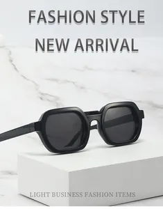 Detailed macro view of square black sunglasses on a minimalist marble display