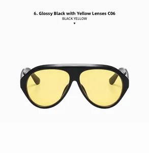 Detail of oversized aviator sunglasses with glossy black frames and transparent yellow lenses
