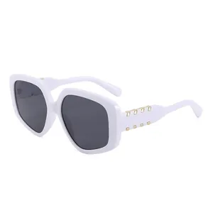 Lunettes de soleil blanches tendance avec verres foncés et rivets en métal doré sur fond blanc