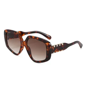 Lunettes de soleil oversize écaille de tortue avec détails dorés sur fond blanc pur