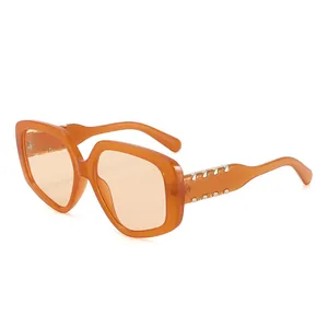 Lunettes de soleil carrées orange translucides avec monture géométrique et accents dorés