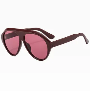 Close-up of oversized burgundy pilot sunglasses with rose pink gradient lenses at 45-degree angle