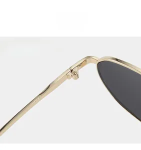 Detail view of sturdy golden metal hinges and dark lenses on modern sunglasses