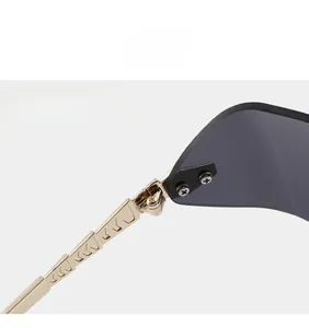 Détail de la charnière en métal doré texturé serpent sur des lunettes de soleil sans monture