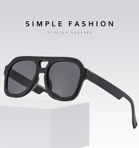 Detailed view of matte black double bridge sunglasses on a white geometric display block