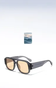 Detail view of double bridge sunglasses with translucent grey frame and orange lenses