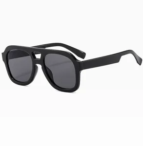 Detail view of stylish black double-bridge aviator sunglasses with dark grey lenses