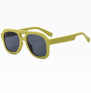 Close-up of olive green double-bridge aviator sunglasses with dark grey tinted lenses