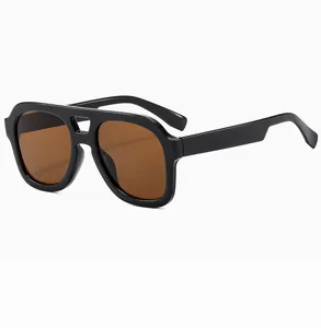 Detail view of stylish double-bridge sunglasses with black frames and brown lenses