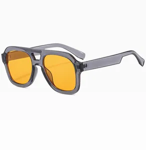 Detail of vintage double-bridge sunglasses with translucent grey frame and orange lenses
