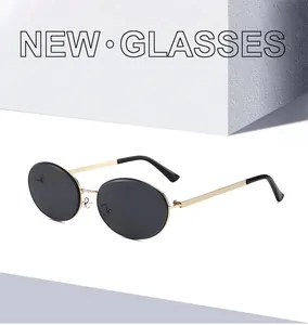Detail of oval vintage sunglasses with gold metal frame and dark grey lenses
