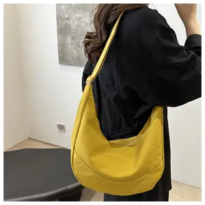 Detailopname van gembergele nylon halve maan tas met textuur en verstelbare riem