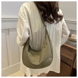 Detail van de hobo-crossbodytas in olijfgroen met opvallende witte gebogen stiksels