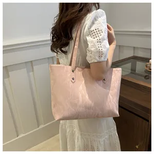 Detail of light pink tote bag with marble texture shown on a female model