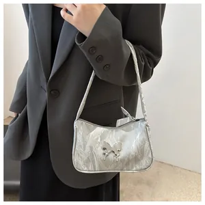 Detail of silver metallic shoulder bag with 3D butterfly buckle and pleated texture
