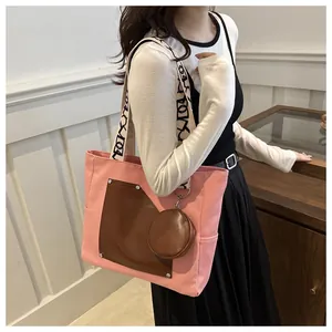 Detail of large capacity pink canvas tote with brown pocket and matching coin pouch