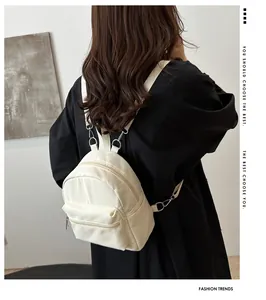 Vista detallada de una mini mochila beige minimalista con correas ajustables en modelo