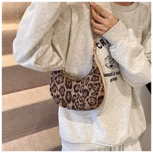 Detail of leopard print hobo bag showing faux fur texture and golden zipper accents