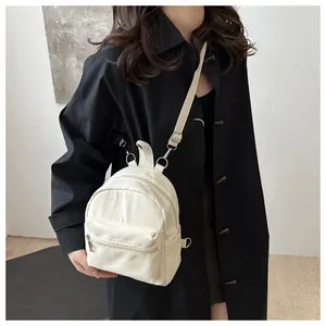 Primer plano de una mini mochila ligera blanco roto usada como bolso bandolera