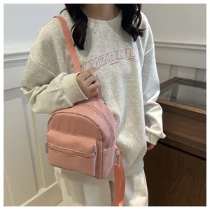 Detalle de la mini mochila de nailon rosa con cremalleras plateadas y correas finas