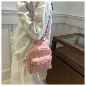 Vista lateral de una mini mochila rosa para mujer, con diseño ligero de múltiples capas