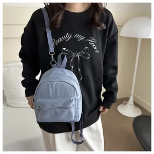 Detalle de la mochila de nailon azul claro impermeable con correas ajustables y bolsillo