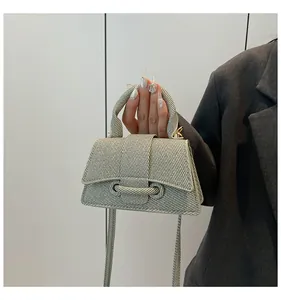 Detailed close-up of light gray woven texture on mini trapezoid crossbody handbag