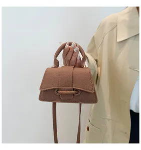 Detailed macro of a brown woven texture hourglass handbag with decorative rope knot detail