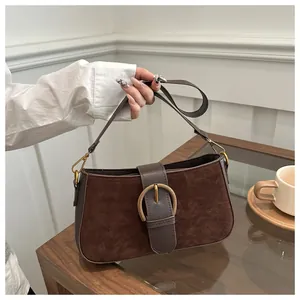 Détail du sac bandoulière vintage en daim marron avec boucle ronde en métal doré