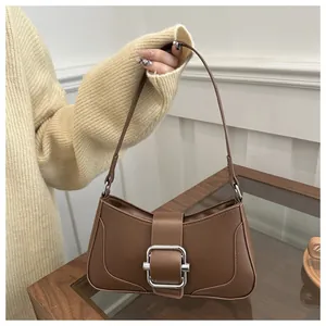 Detailed view of brown leather half-moon shoulder bag with large silver square buckle