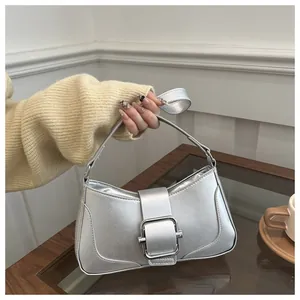 Detail of silver metallic handbag featuring a large square buckle and smooth glossy finish