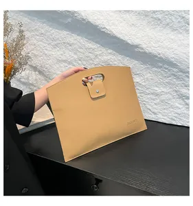 Detalle de la funda de portátil en cuero lichi camello con cierre de botón metálico