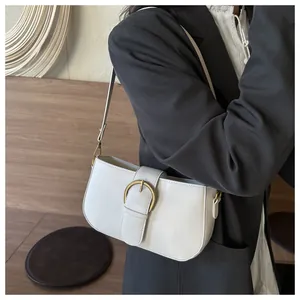 Détail du sac sous le bras beige minimaliste avec boucle en métal fer à cheval doré