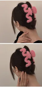 Detail of pink plush hair claw clip showing fluffy wave texture on elegant hair updo