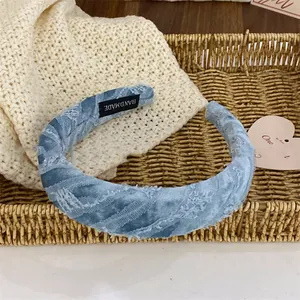 Vue détaillée du serre-tête en dentelle bleu clair fait main sur un plateau tressé