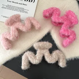 Three large plush hair claws in pink, rose, and beige with fuzzy wave-shaped design