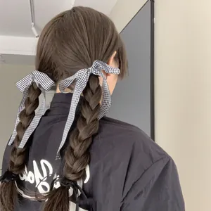 Classic black and white gingham bow hair ribbon tied on braids for a stylish look