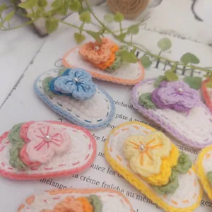 Détail de barrettes fleurs au crochet faites main avec fil coloré et perles blanches