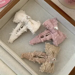 Macro detail van drie tweed strik haarspelden met hartvormige strass steentjes en eendenbekclip