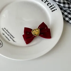 Detail einer roten Samt-Haarschleife mit graviertem Herz und silbernem Funkeln